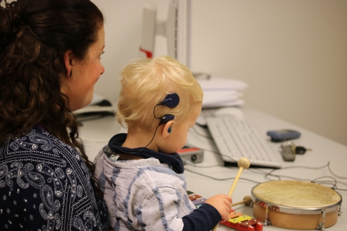 Kleinkind mit Cochlea-Implantat beim Musizieren