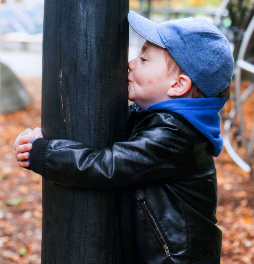 Kind umarmt einen Baum